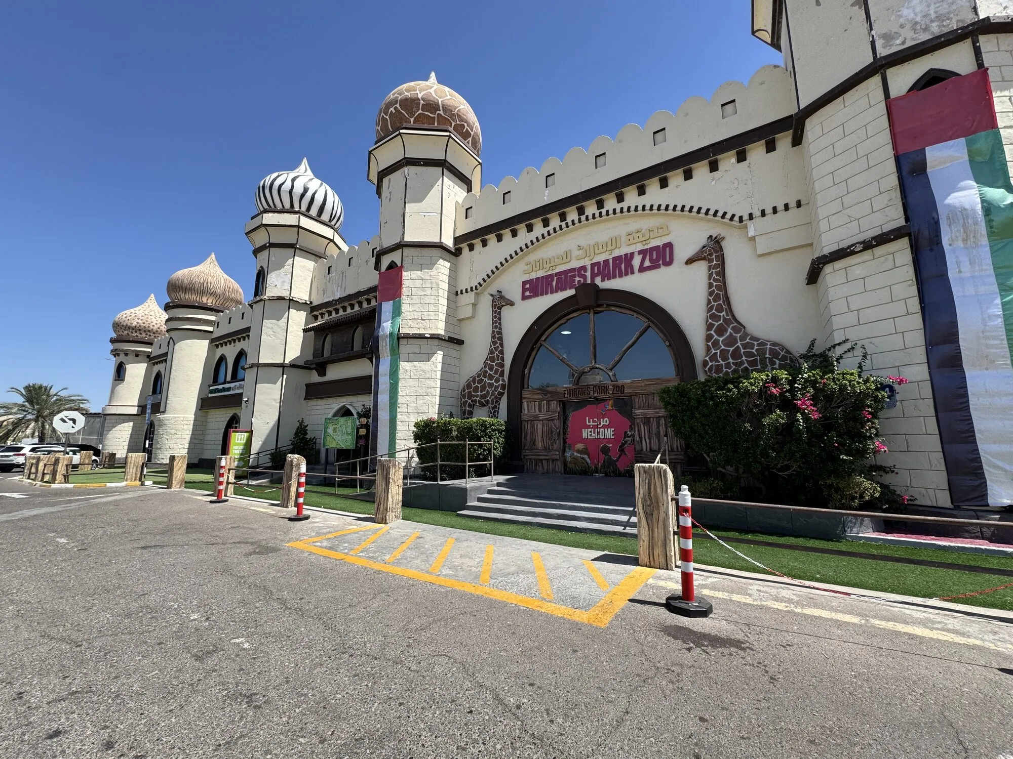 Burgartiger Eingang des Emirates Park Zoo mit Giraffen-Skulpturen am Torbogen