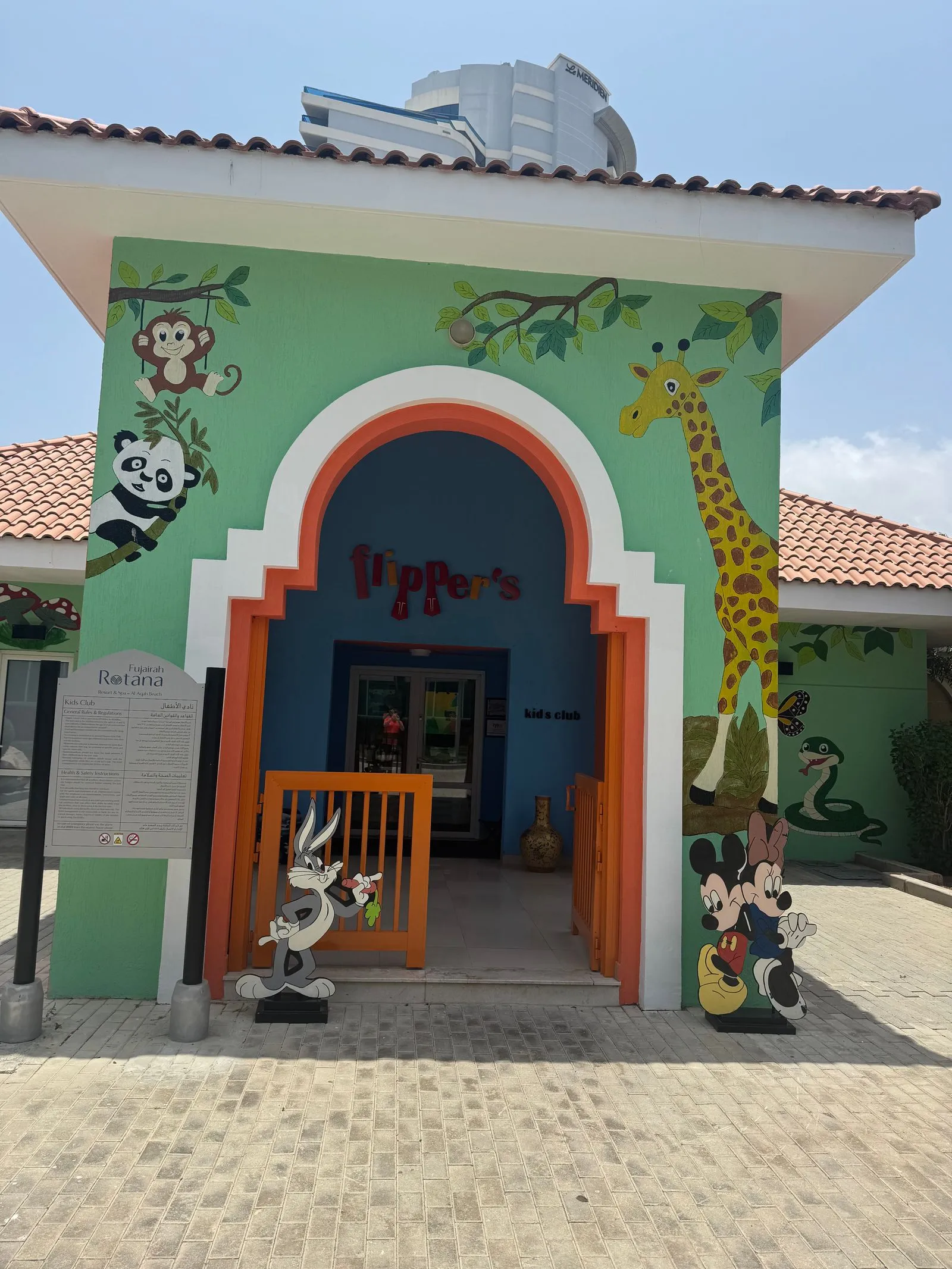 Eingang des Kinderclubs „Flipper's" mit gemalter Giraffe und Comicfiguren